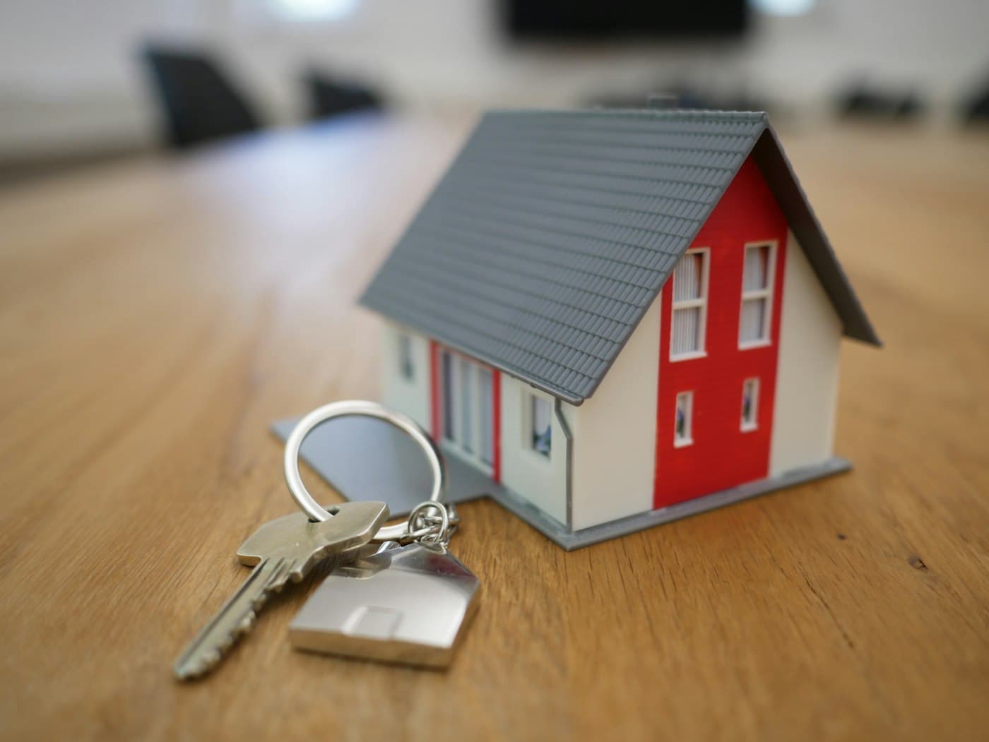 House keys on a table next to a small model home